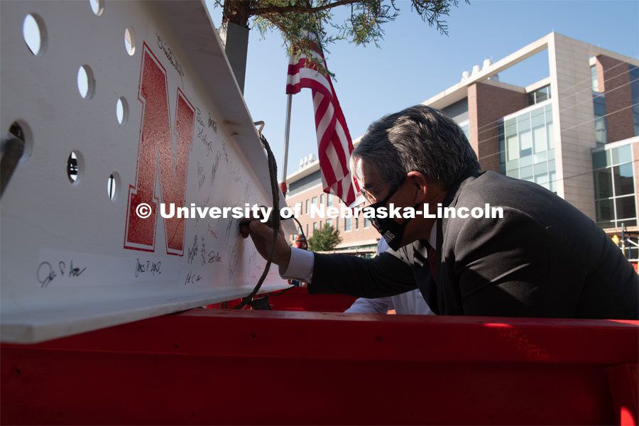 College of Engineering Dean Lance Perez adds his signature to the last beam before it is placed. Due to COVID-19 precautions, a public ceremony was not able to be held. Instead, signatures from college and university supporters and others involved in the Phase I project were gathered either remotely or by signing the beam individually. The final beam was installed at the topping off ceremony for Engineering Project, August 26, 2020. Photo by Greg Nathan / University Communication.